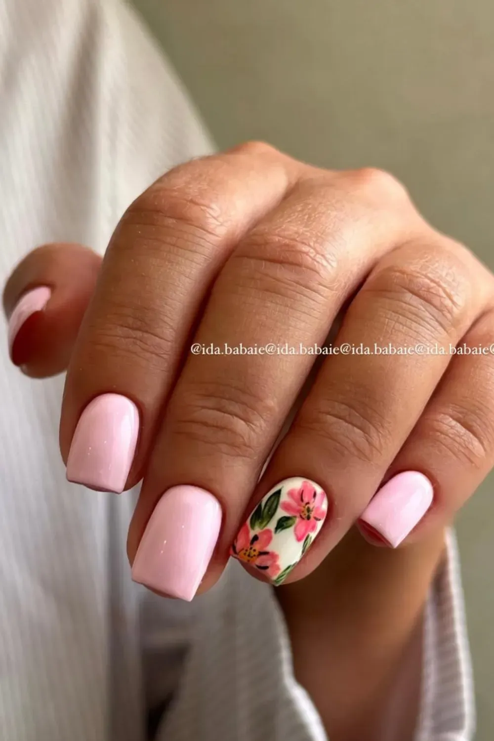 A soft pink base with a single hand-painted floral accent nail, showcasing intricate flower details.