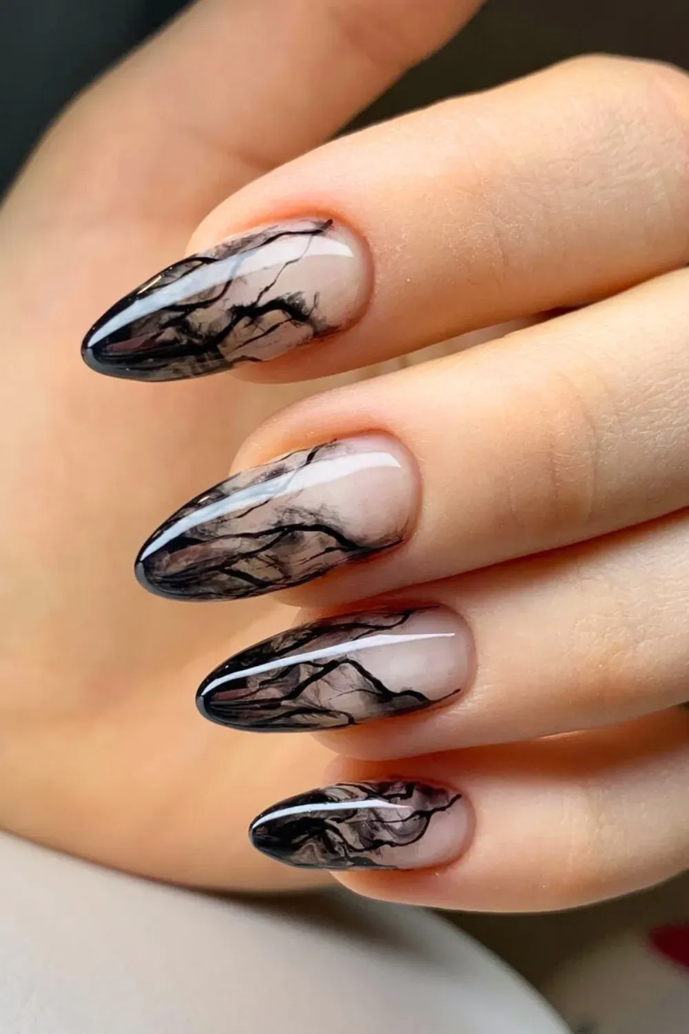 Sleek black marble nails with a glossy and matte finish, offering an elegant and edgy design