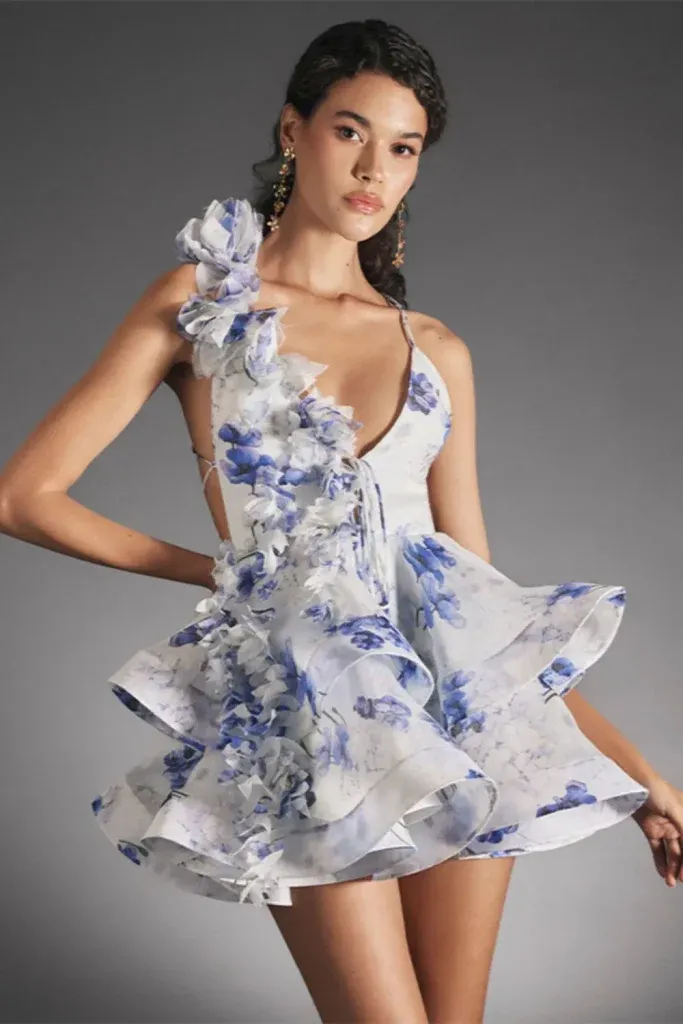 3D Floral Ruffle Mini Dress - Woman wearing a dramatic blue floral mini dress with ruffled layers and 3D details.
