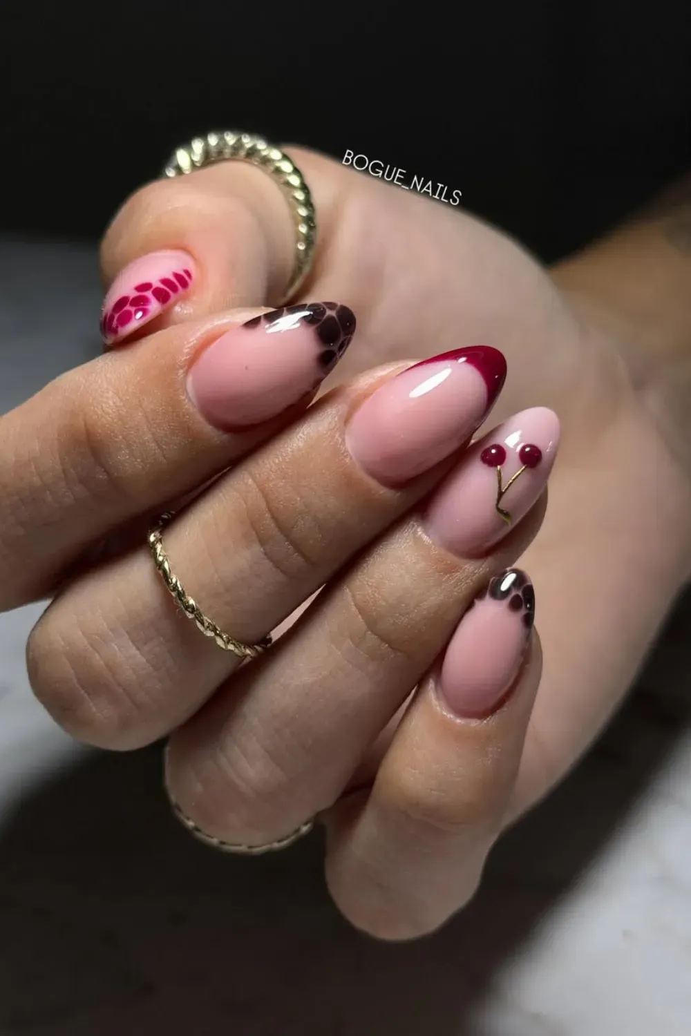 Soft pink nails with cherry blossom designs, accented with tiny red cherry motifs