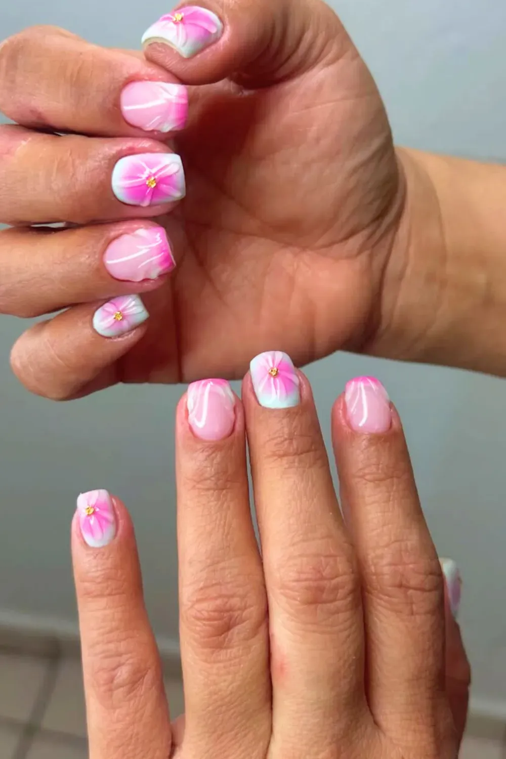 Pink and white floral short nails with delicate flower accents.