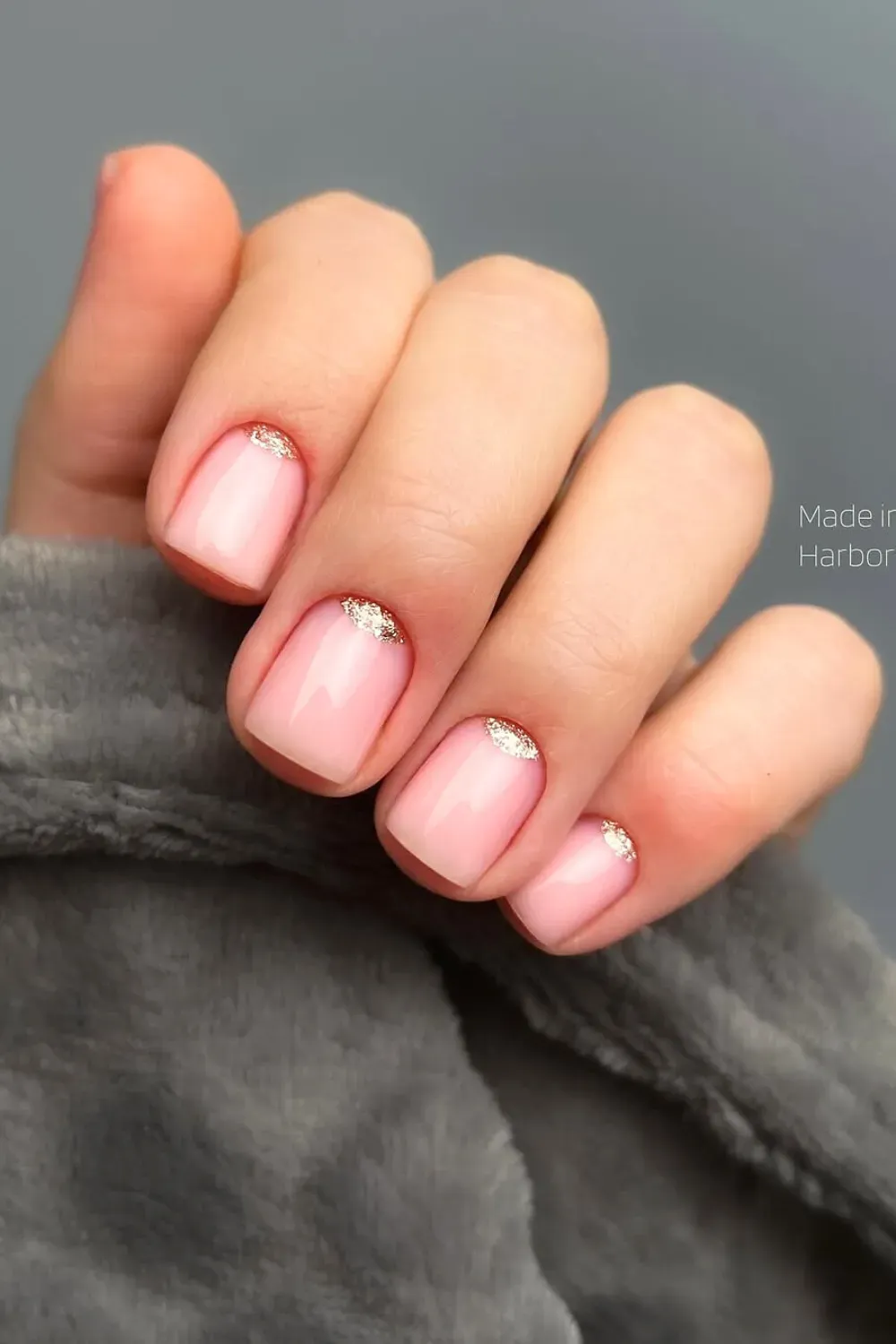Soft pink short nails with gold accent tips for an elegant look.