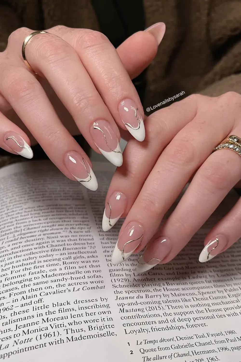 Glossy French tips with metallic gold accents and sharp tips