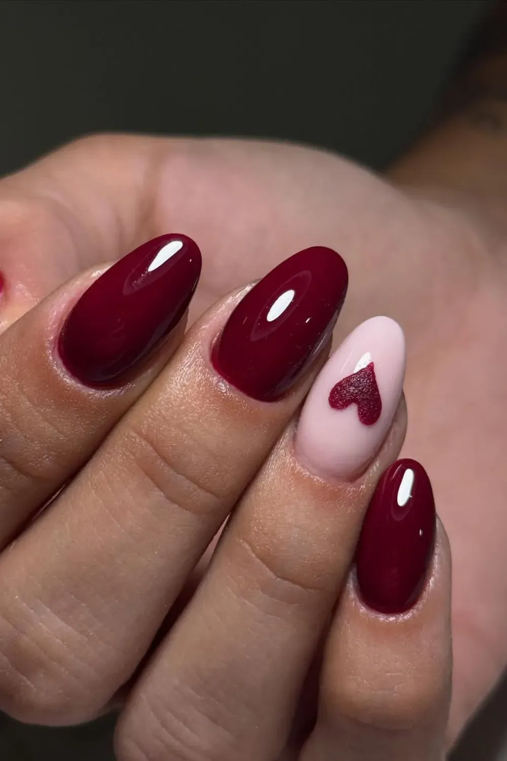 Soft red nails with heart designs for a romantic, feminine vibe
