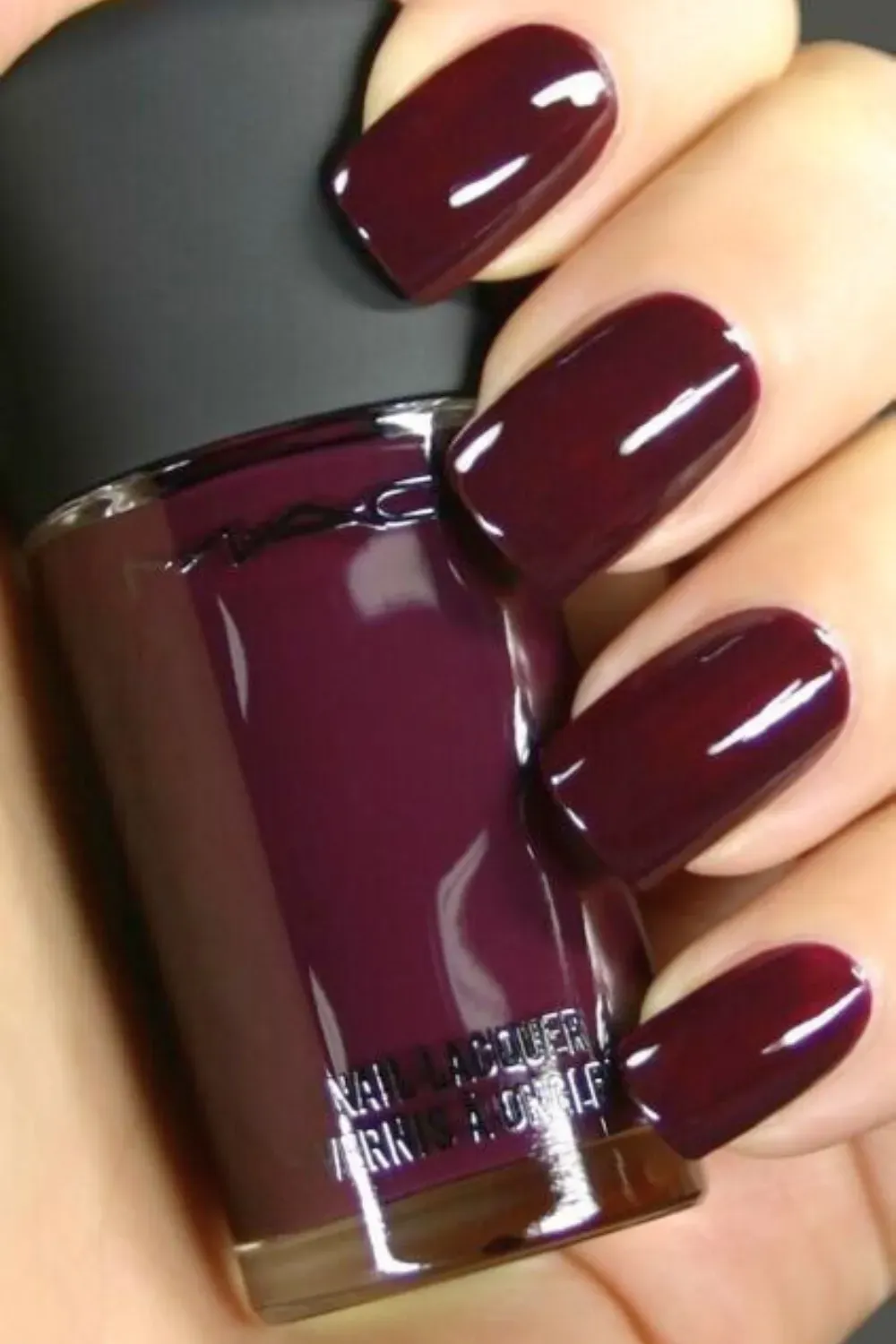 Deep burgundy glossy nails in a square shape, paired with stylish rings for an elegant appearance