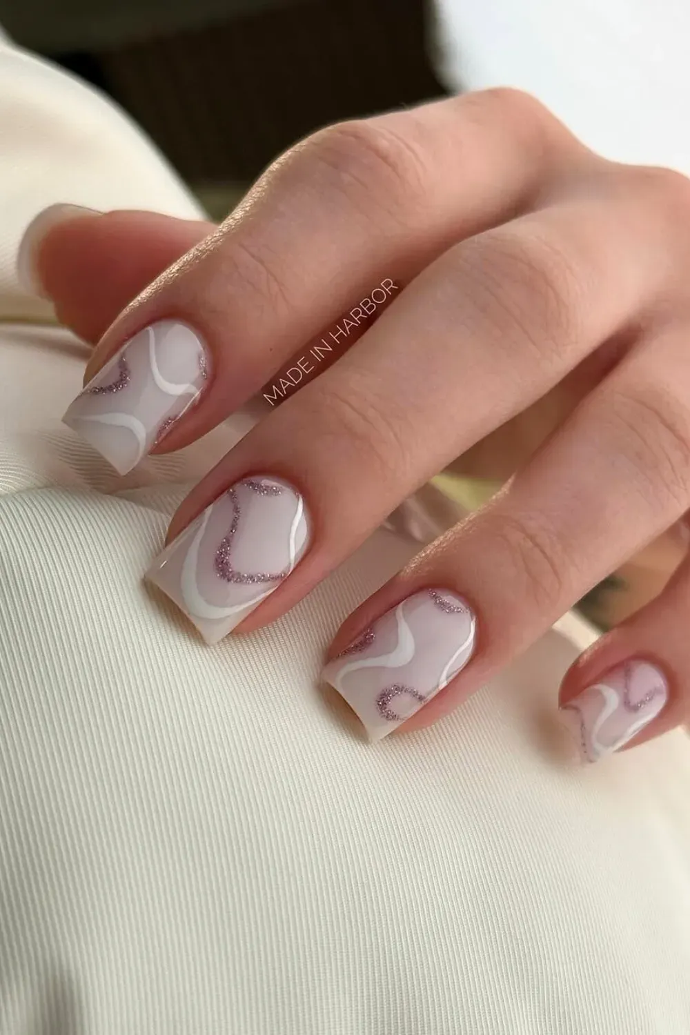 Pastel marble swirl nails with a soft pink and white design.