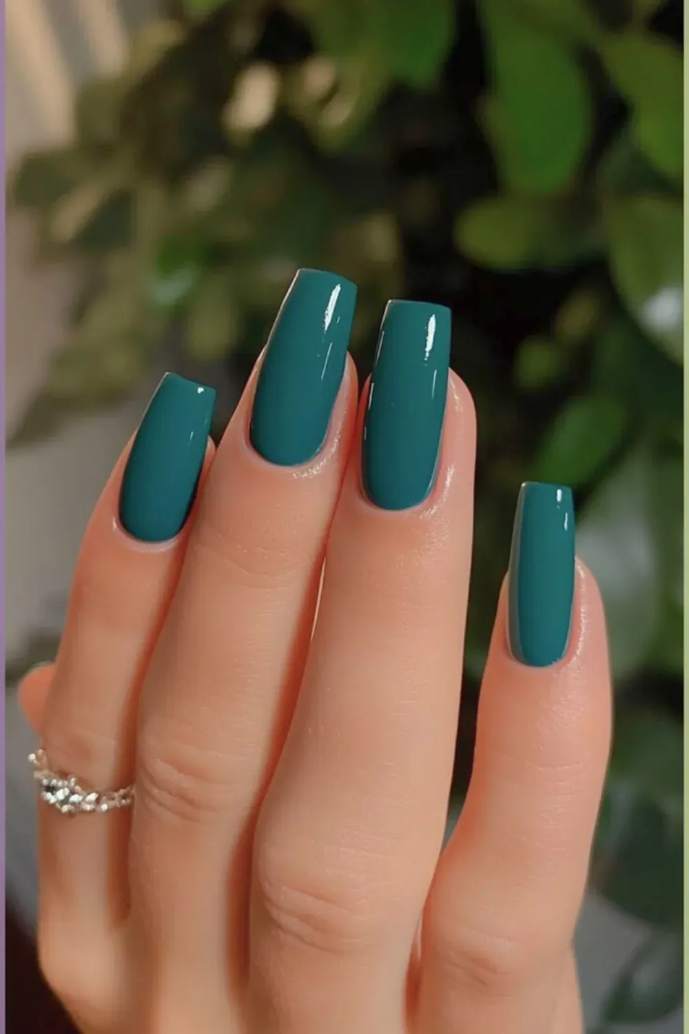Vibrant teal square nails paired with stylish rings, offering a bold yet chic look.