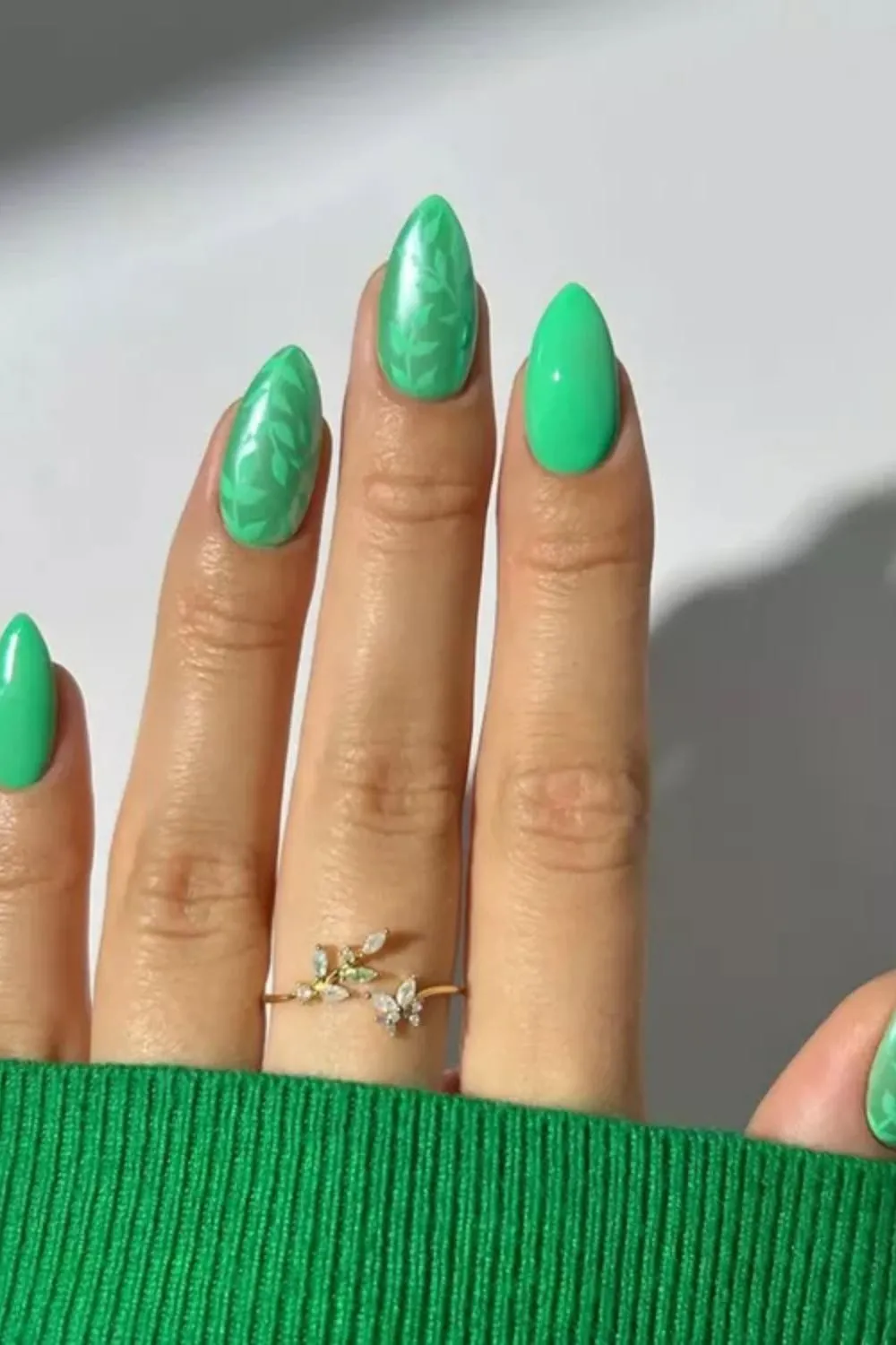 Leafy Emerald Green Nails - Green almond nails with painted leaf designs and solid green accents