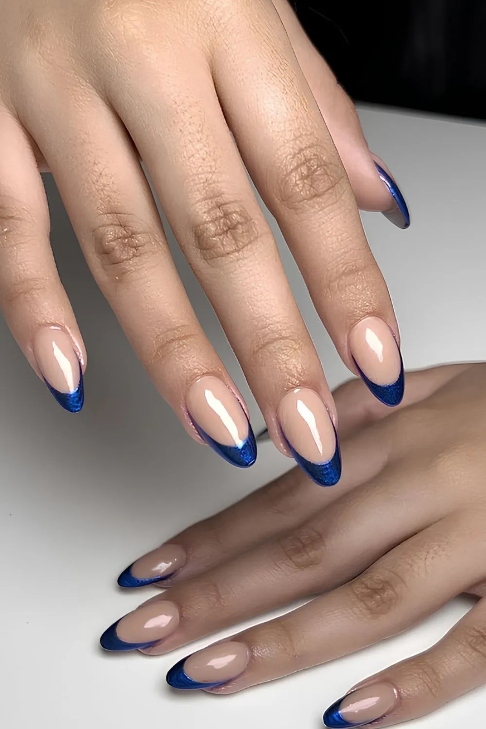 Blue Tip French Manicure - Almond nude nails with dark blue French tips.