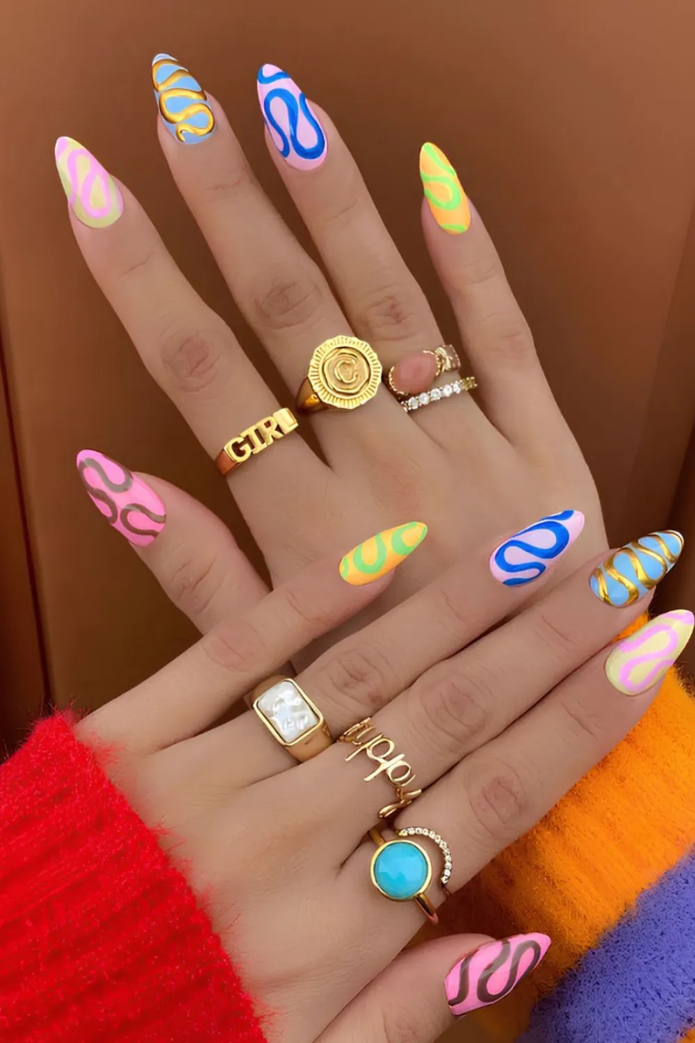 Neon Swirl Nails for Spring - Long almond-shaped nails in multiple bright colors with retro swirl designs.