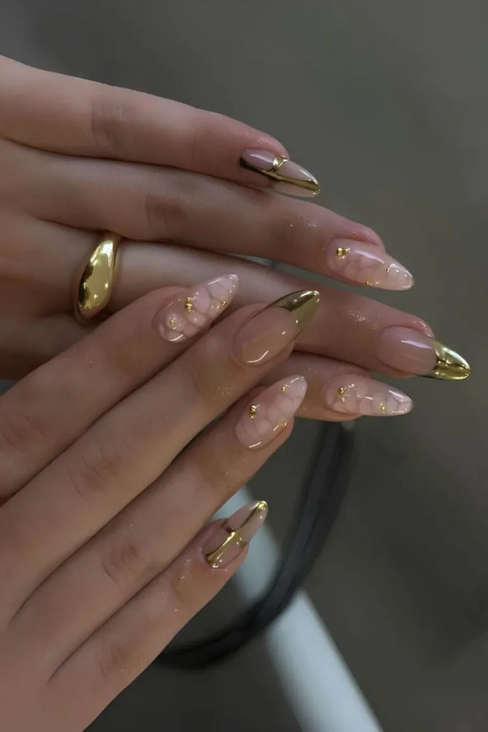 Gold Embellished Nail Art - Nude nails with gold French tips and delicate golden embellishments.