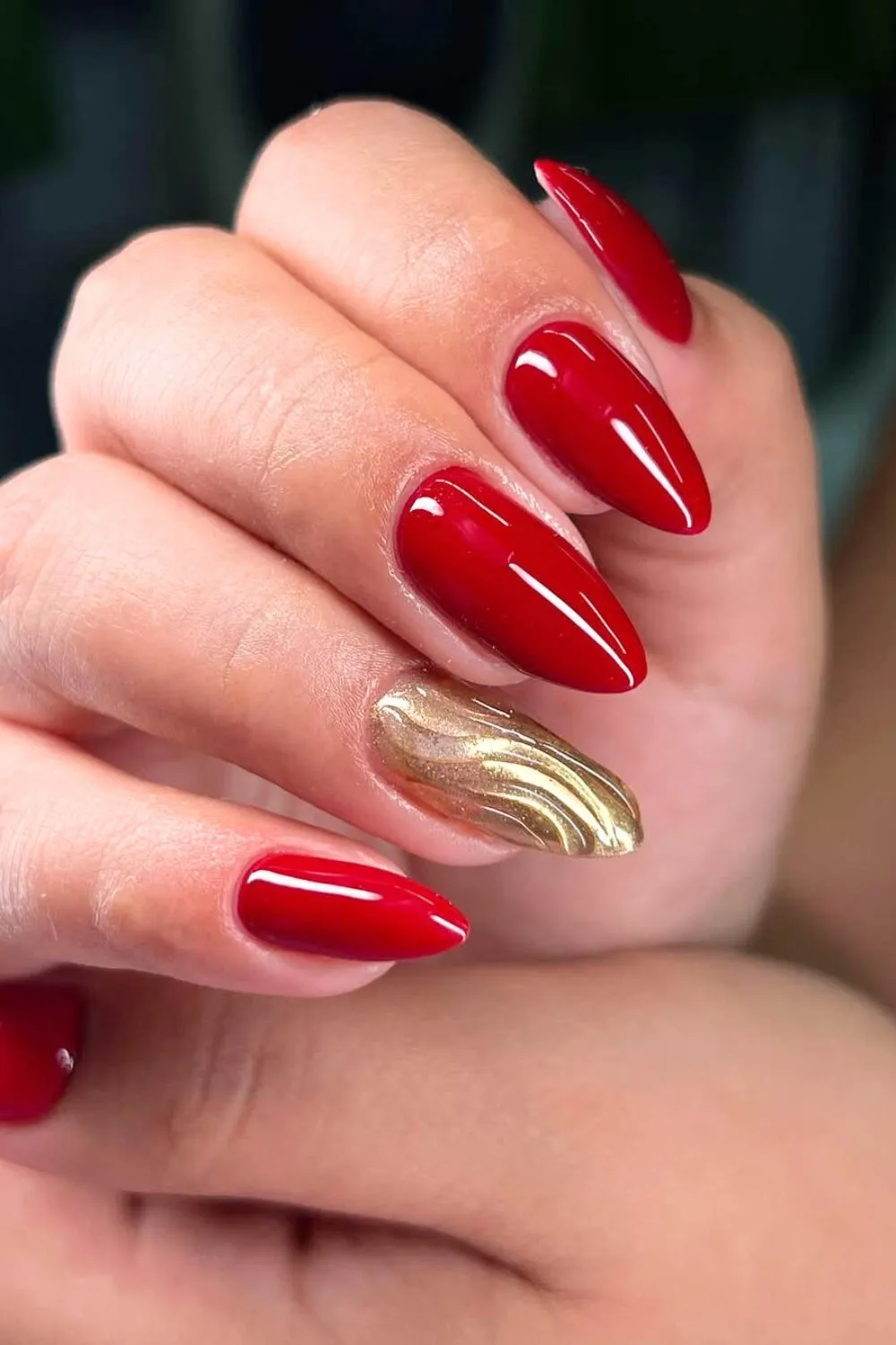 Red and Gold Accent Nails - Almond-shaped red nails with one gold 3D accent nail