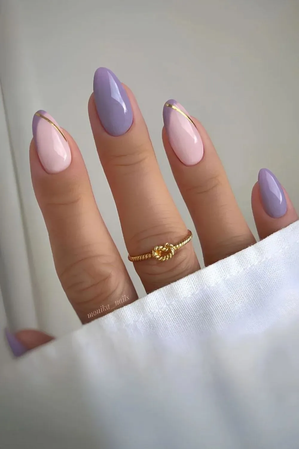 Pastel Nails with Gold Accents - Almond-shaped nails painted in lilac and blush pink with thin gold stripe details.