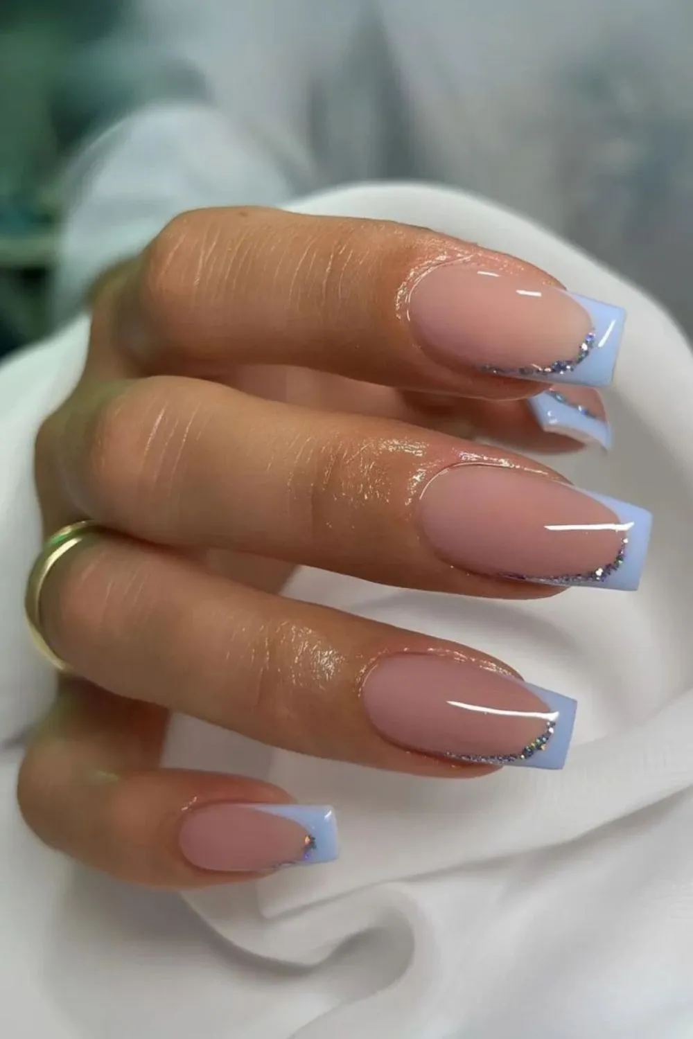 Glittery Blue French Manicure - Pale pink nails with square-shaped light blue French tips lined with glitter.