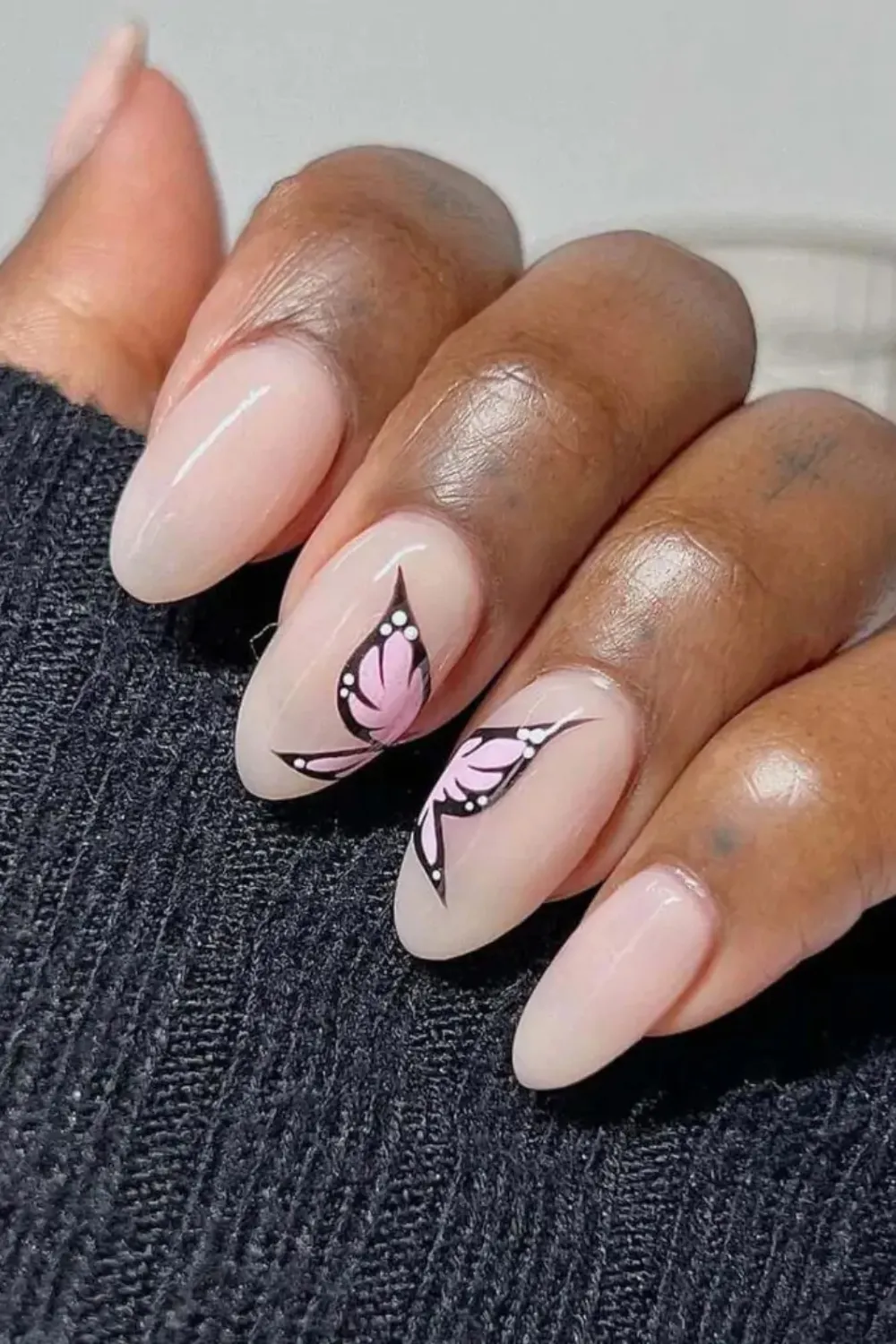 Minimalist Butterfly Accent Nails - Nude nails with small black butterfly accents for a chic and subtle design.