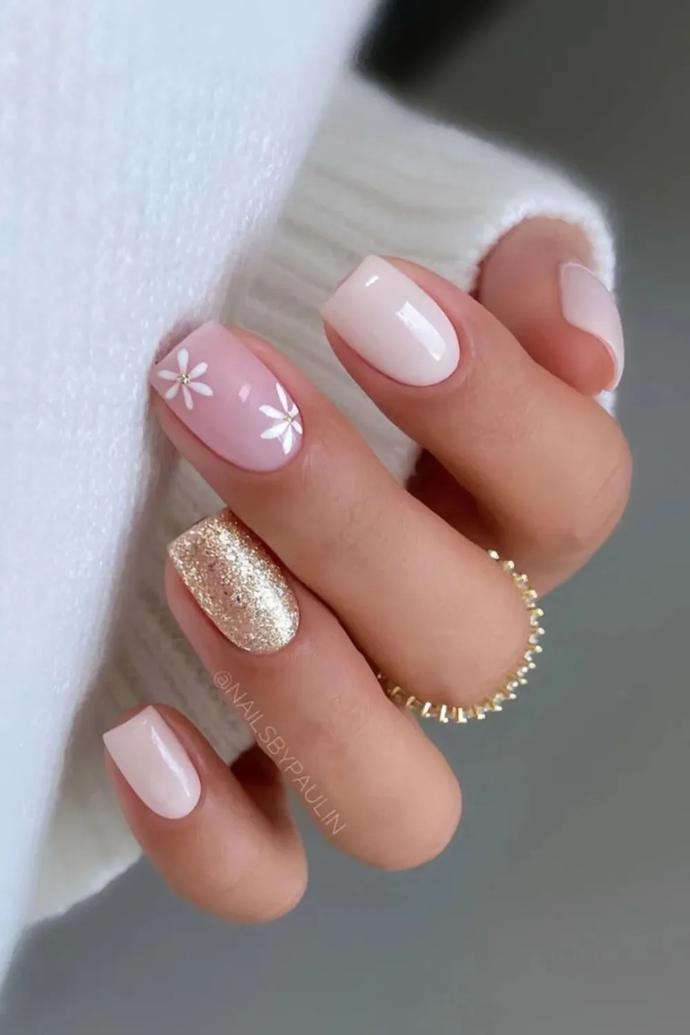 Nude Nails with Flowers and Glitter - Nude square-shaped nails with white daisy flowers and a gold glitter accent nail.