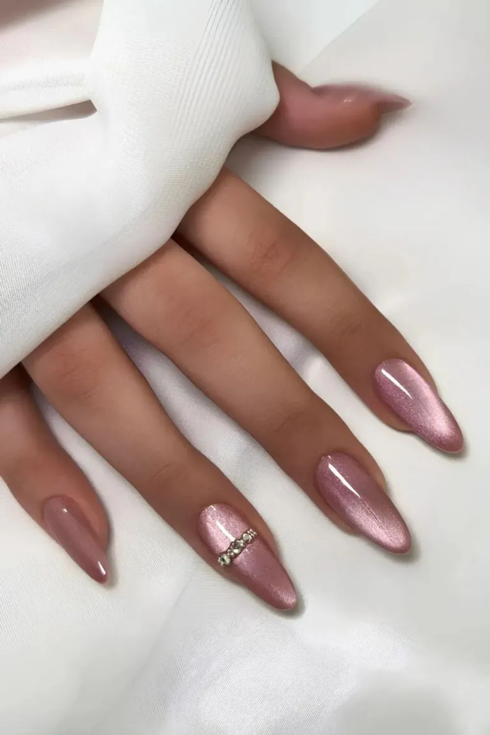 Pink Velvet Nails with Rhinestones - Almond-shaped shimmering pink velvet nails with gem accents on the ring finger.