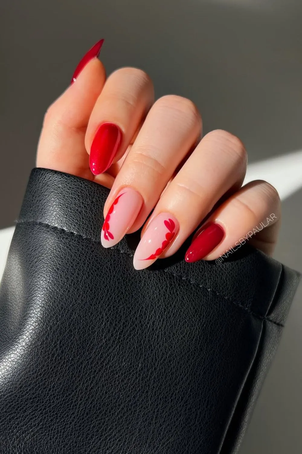 Red and Nude Nail Design with Leaf Art - Hand with red and nude nails featuring red leaf-like patterns