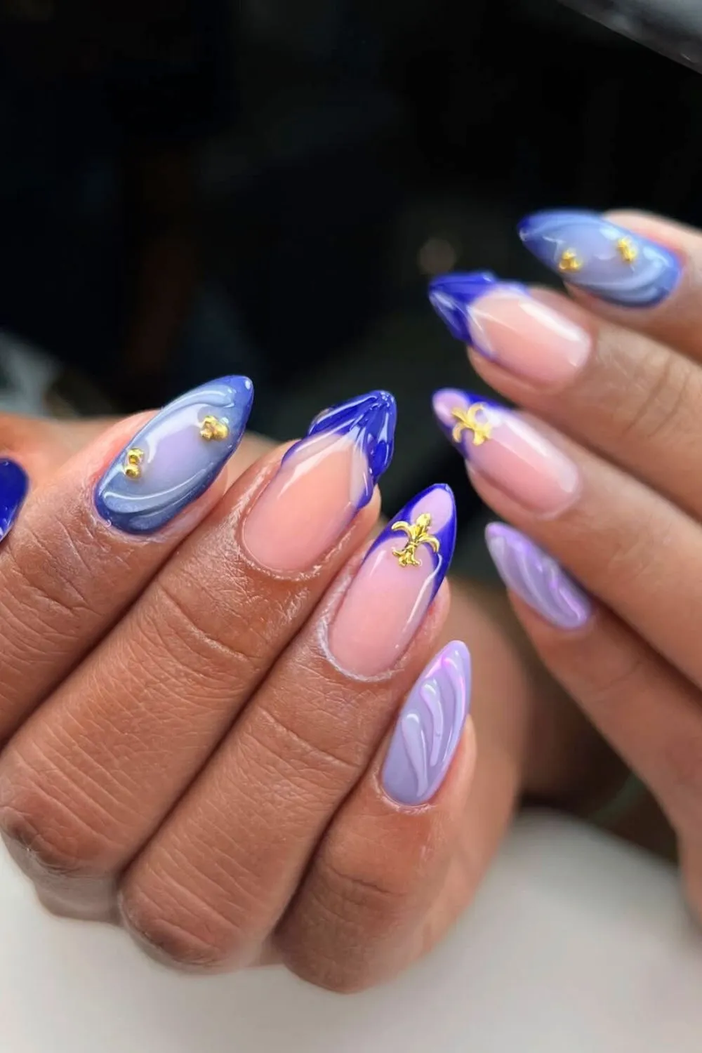 Blue Swirl Nails with Gold Accents - Almond nails with blue and lavender swirls and gold star decals