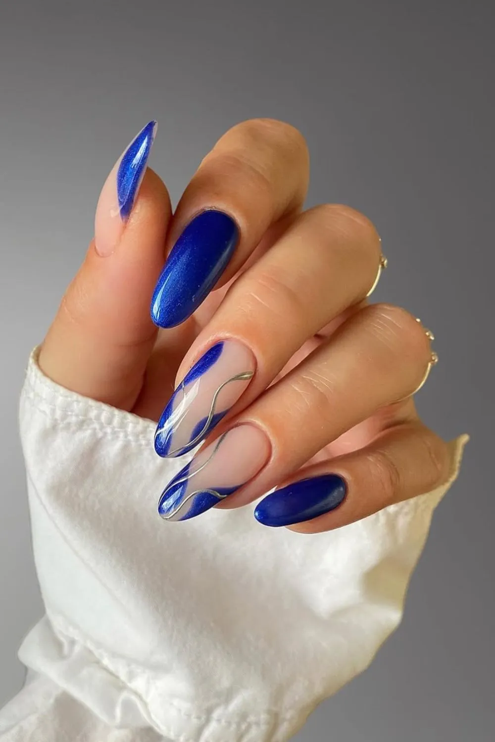 Metallic Sapphire Nail Design - Nails with deep sapphire blue polish and silver-lined wave accents.