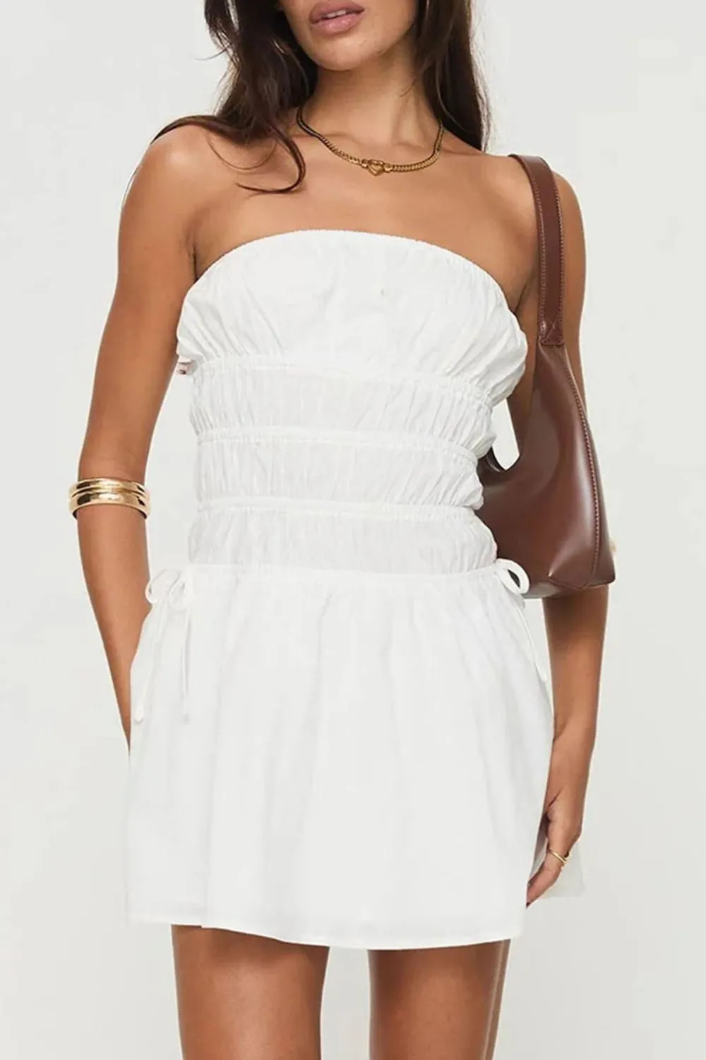 Strapless White Ruched Mini Dress - Woman wearing white strapless mini dress with gathered detailing