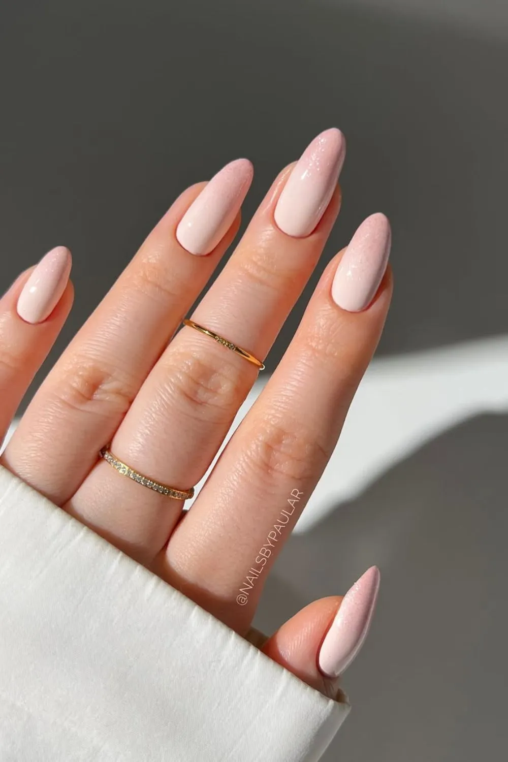 Nude Shimmer Spring Nails - Hand with nude pink nails lightly dusted with shimmer at the tips