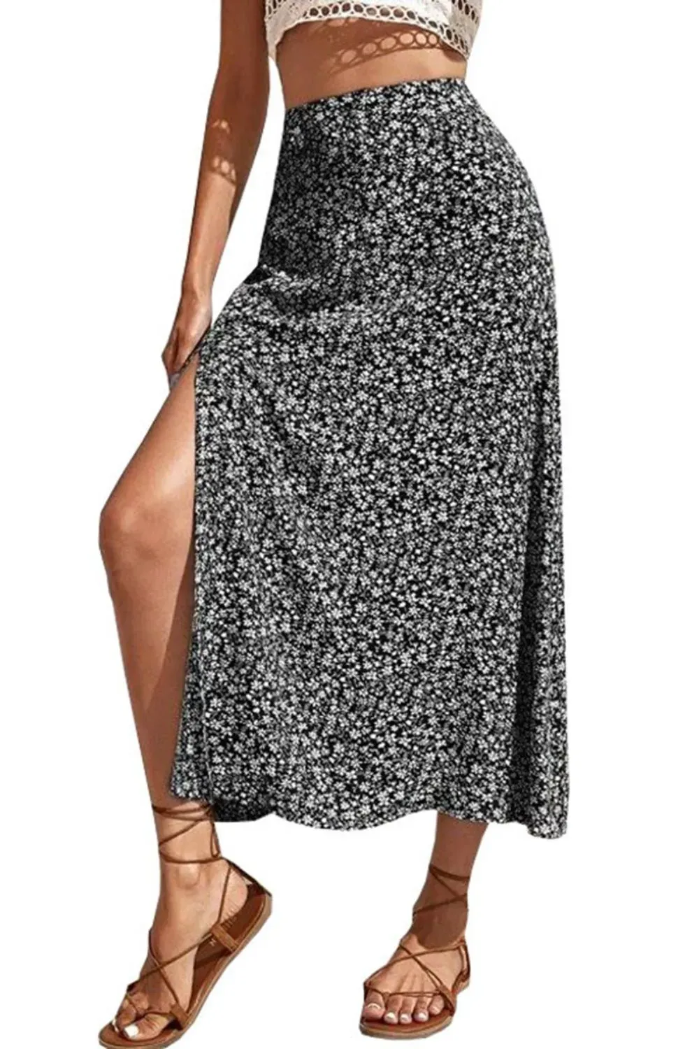 Woman in black floral slit skirt paired with crop top and lace-up sandals.