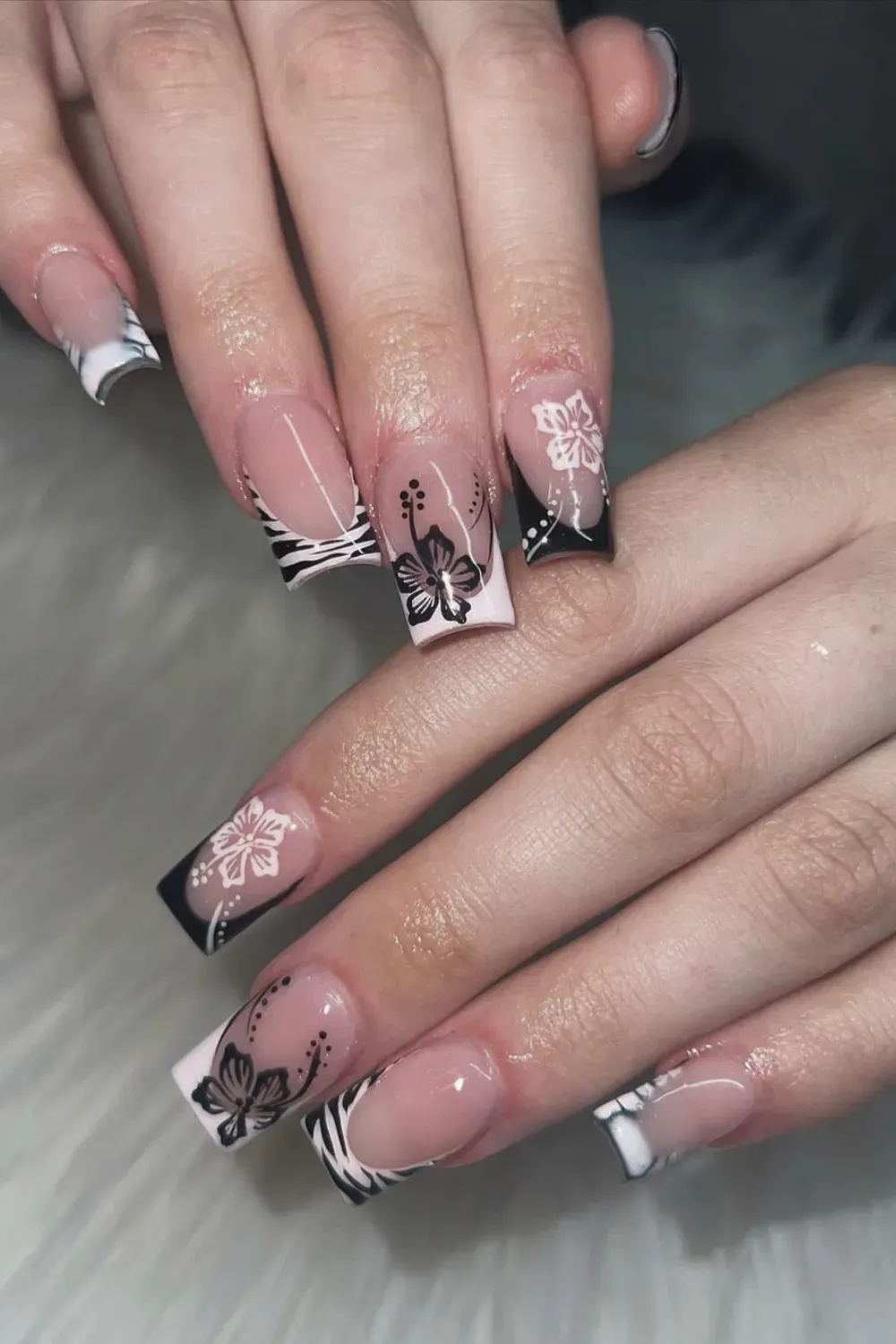 Black and White Floral French Tips with Zebra Stripes - Bold black and white French tips featuring floral designs and zebra stripes for a chic and edgy style.