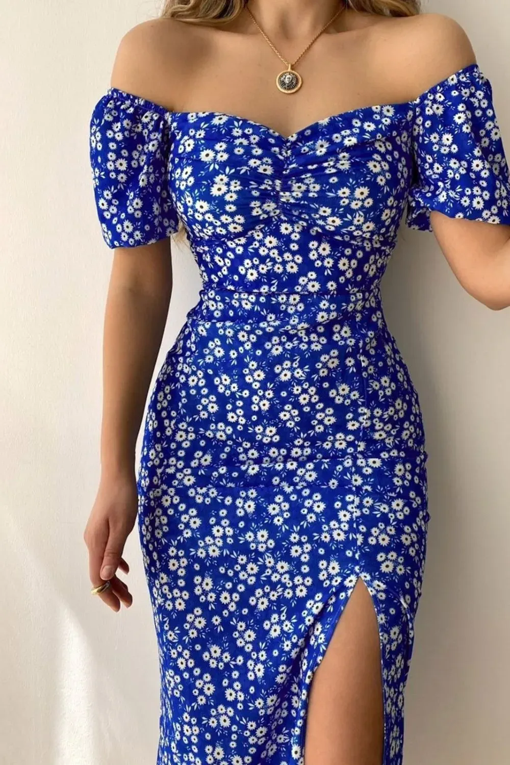 Close-up of a blue off-shoulder floral dress with a side slit and ruched bodice.