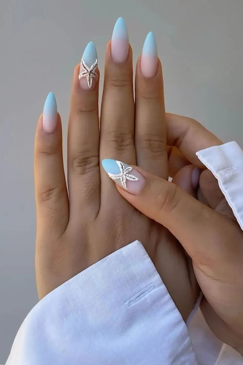 Elegant blue ombre nails with a 3D starfish design for a sophisticated beachy look