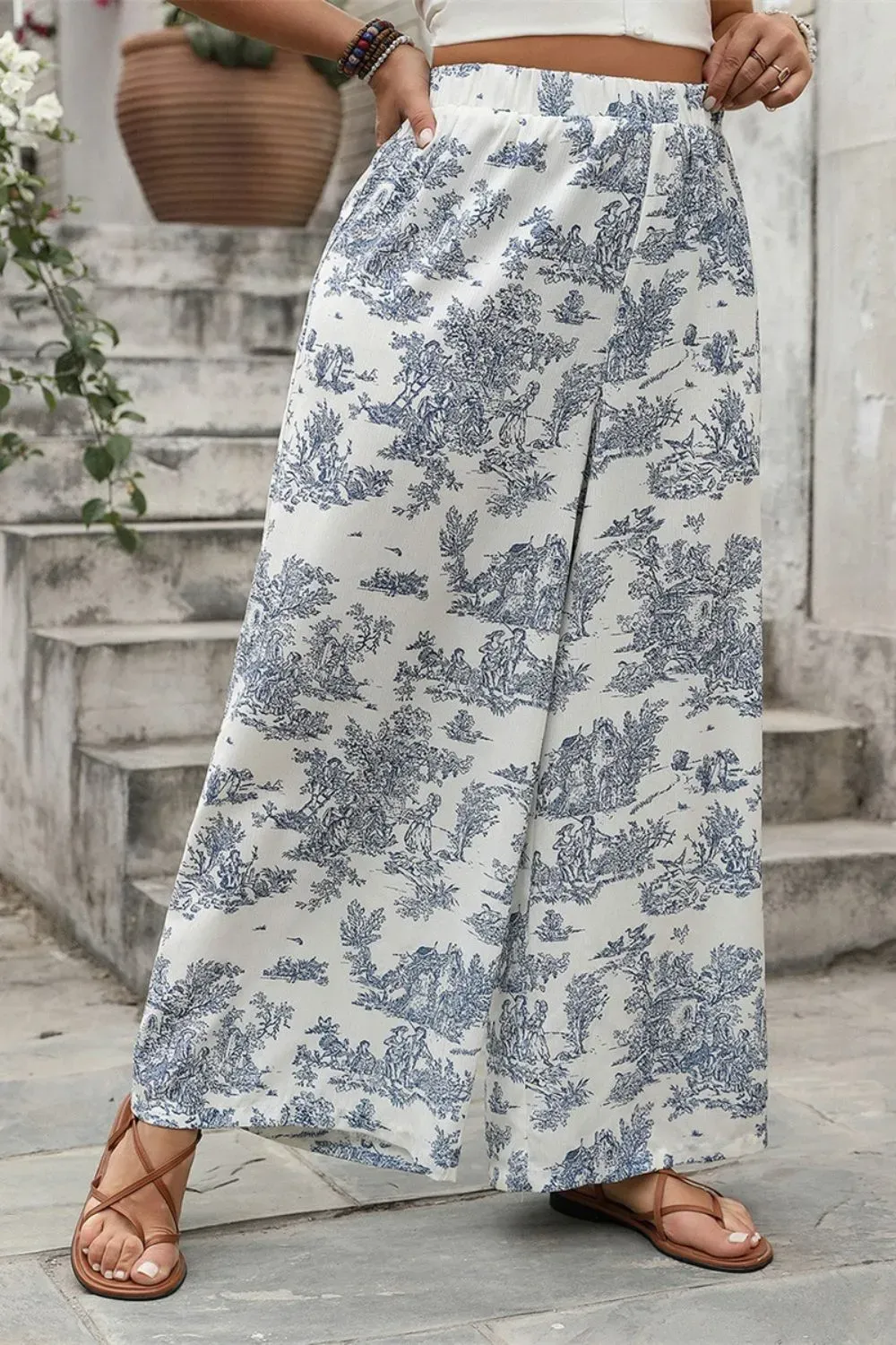Close-up of blue toile floral palazzo pants with brown sandals.