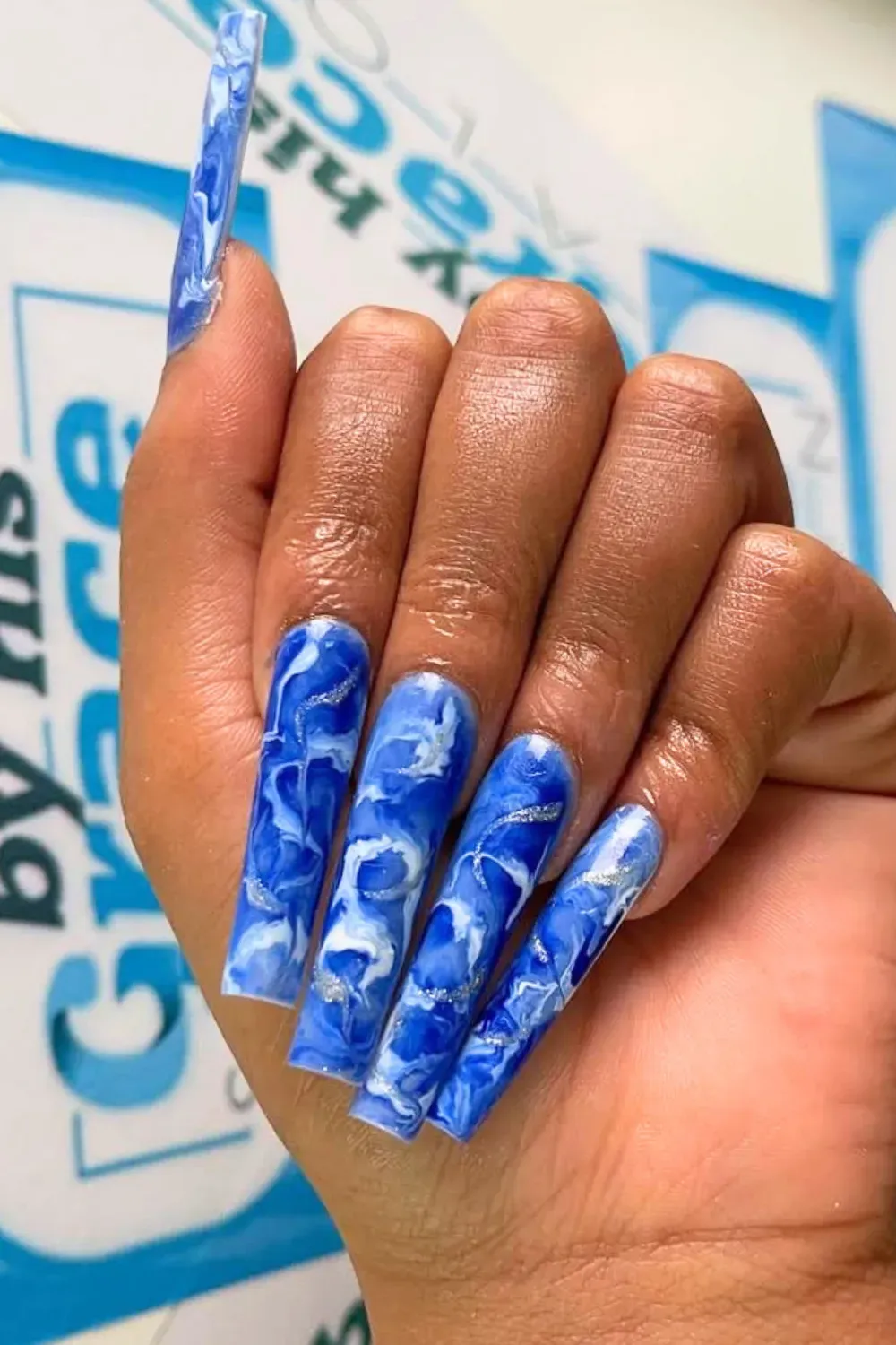 Blue and White Swirls with Flower Details - Blue and white swirl nails with blue floral details on each nail