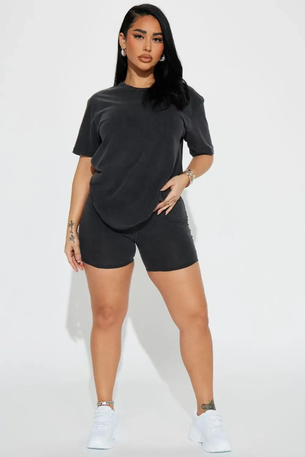 Cozy Matching Set for Comfort - A woman wearing a matching charcoal gray T-shirt and shorts set with white sneakers