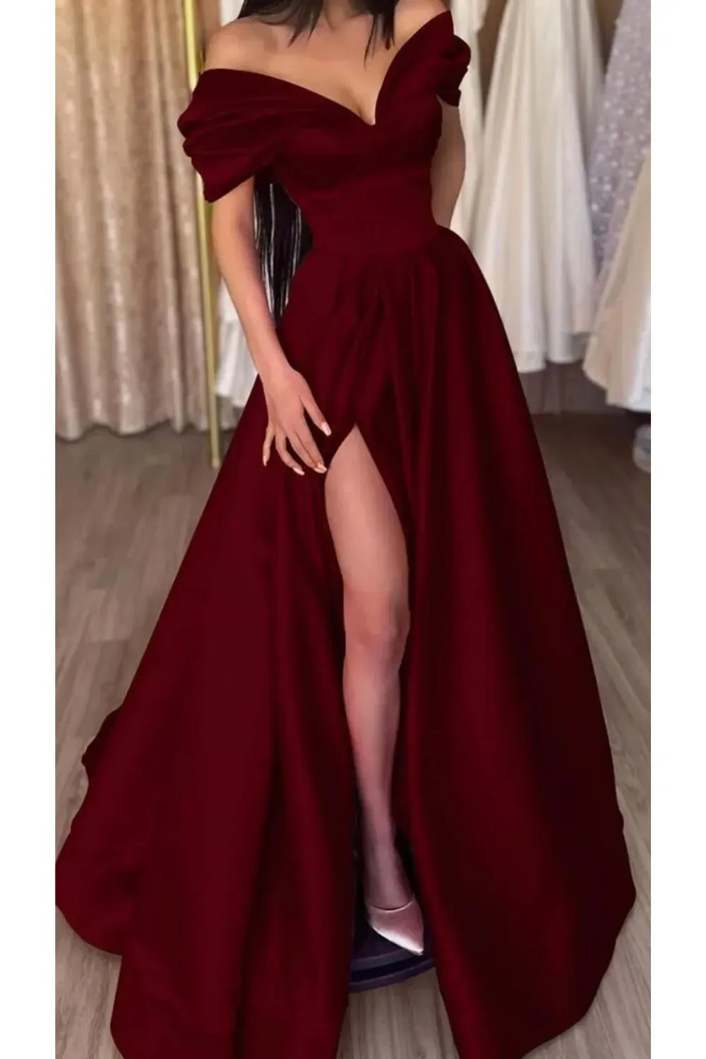 A bold Bardot-style red dress with elegant draping and high slit