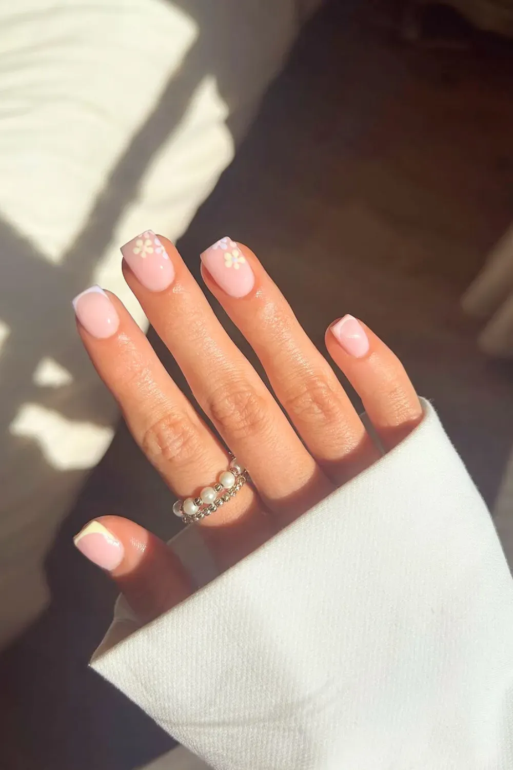 Soft pink nails with tiny white daisy accents