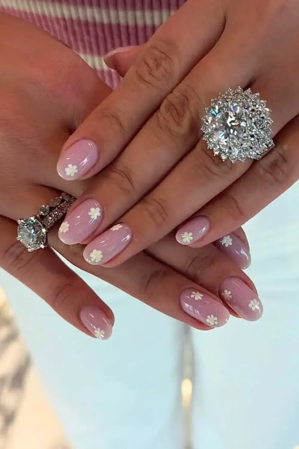 Soft pink nails adorned with white flowers for an elegant and simple back-to-school style