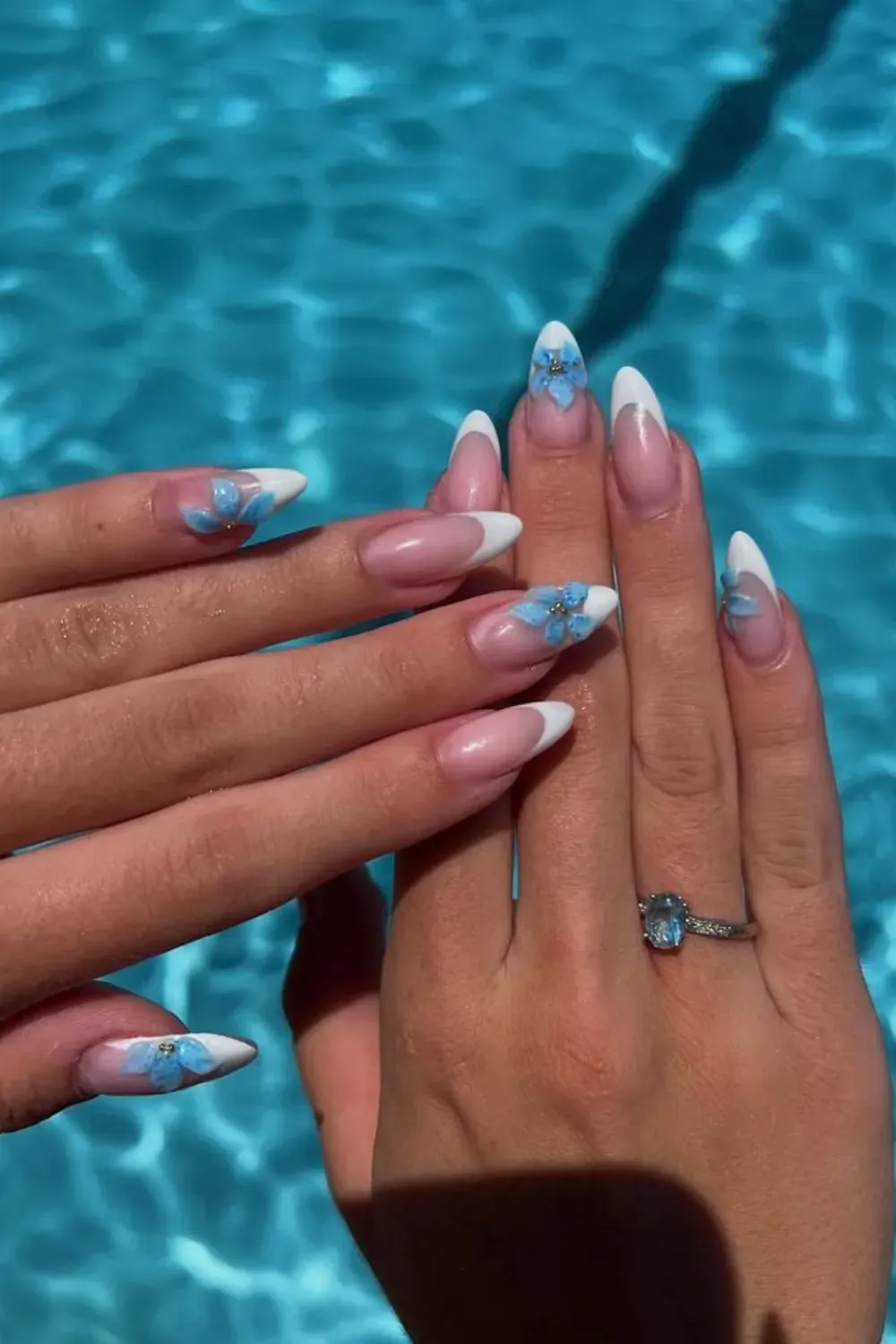 French Tips with Floral Accents - Classic French tips with delicate blue floral accents