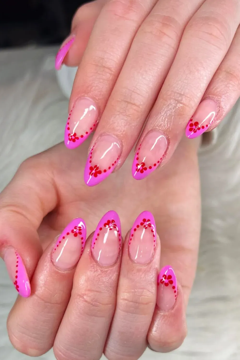 Subtle White French Tips with Red Floral Art Alt Text: Soft white French tip nails with intricate red floral accents on the ring finger