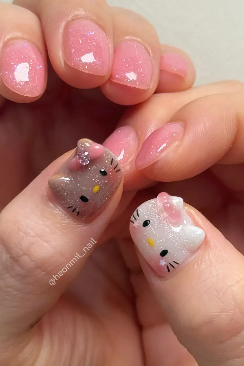 Playful Hello Kitty nail art with pink glittery accents