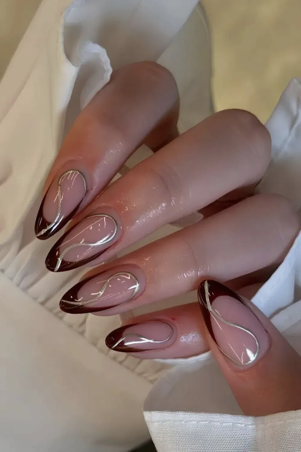  Brown nails with metallic gold swirls for an artistic touch