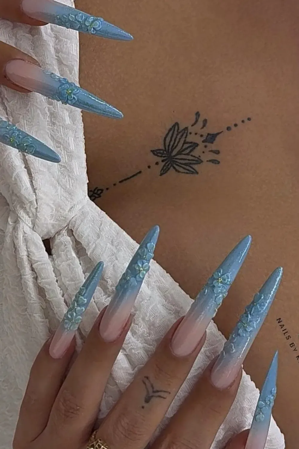 Subtle pink and blue ombre nails with delicate floral art
