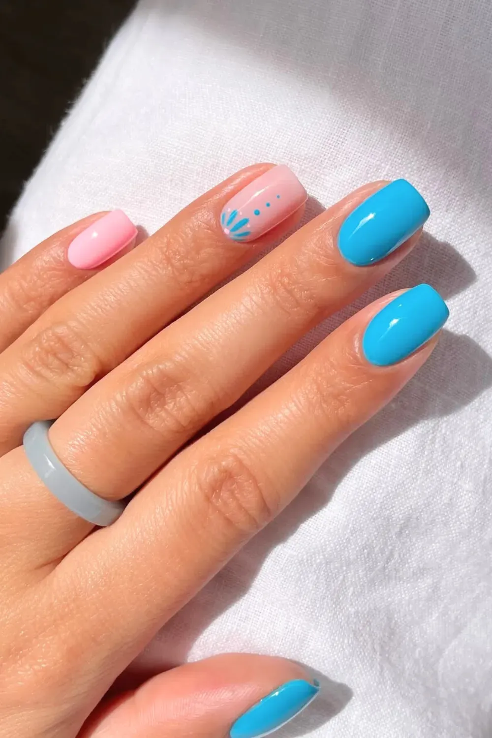 Soft blue and pink ombre nails with delicate floral accents