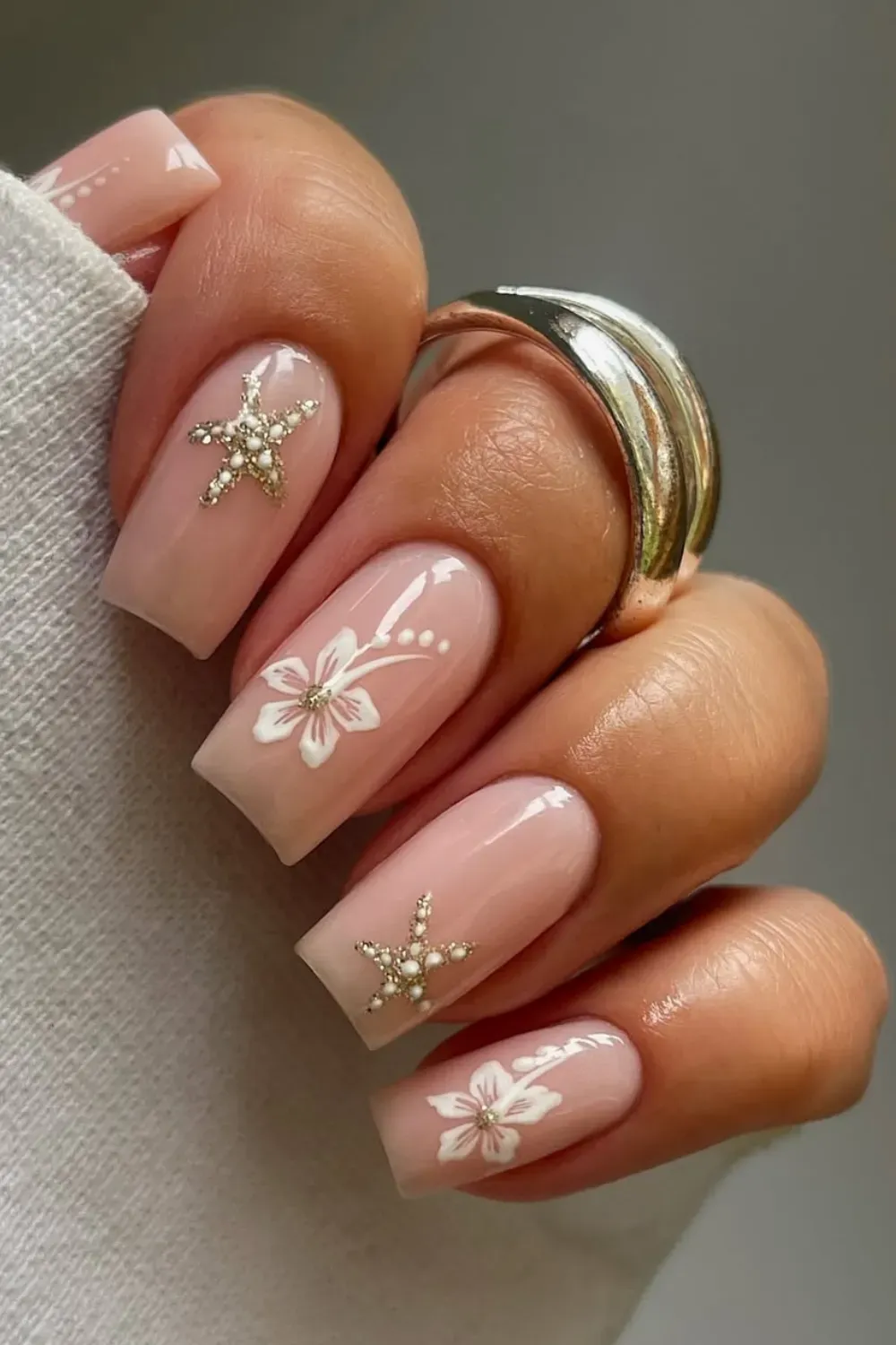 Classy nude nails adorned with gold starfish details for a refined beach-inspired look