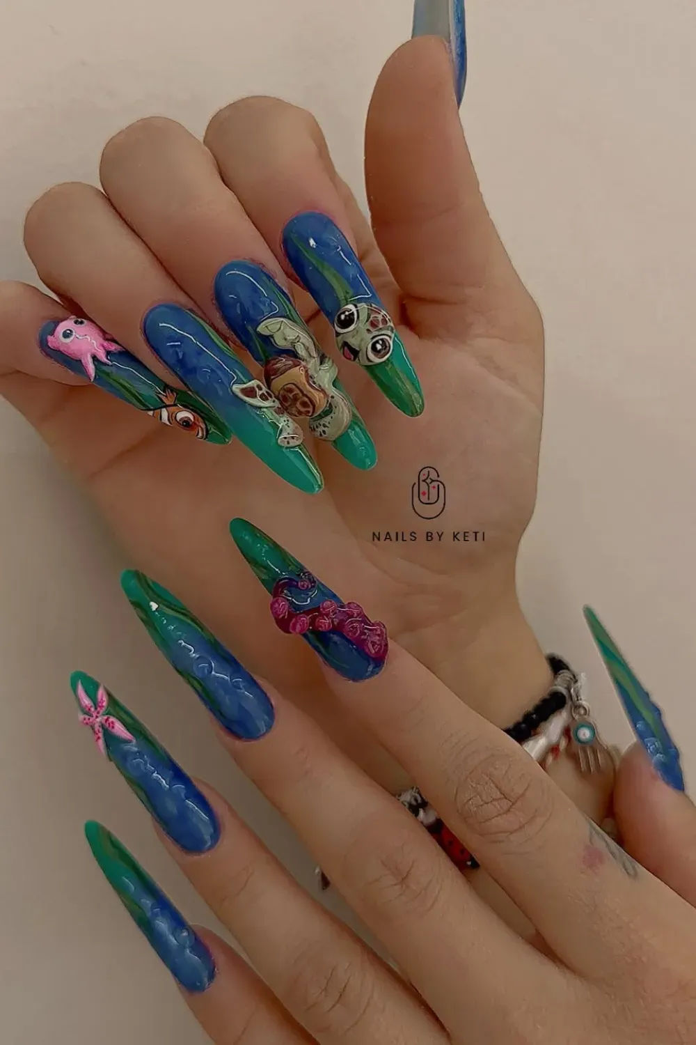 Colorful acrylic nails featuring 3D sea creatures and ocean-inspired hues