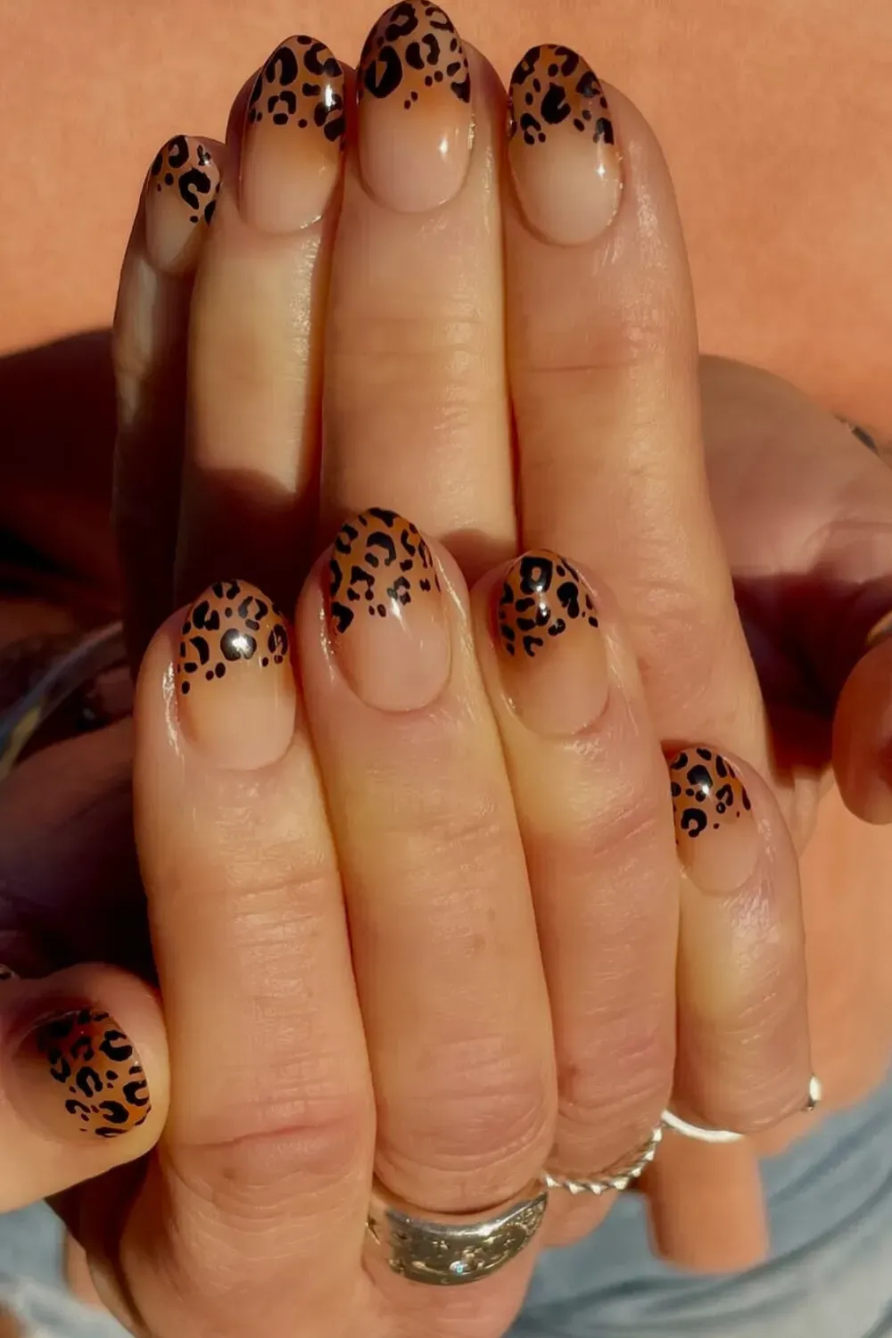 Ombre leopard print nails with a nude base and black leopard spots