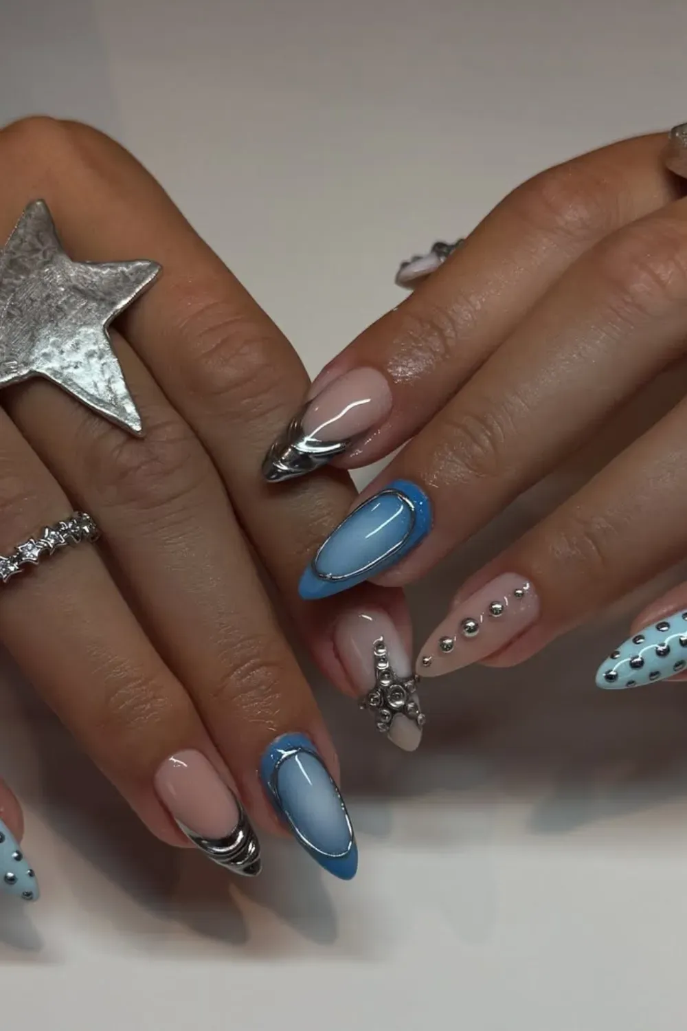 Blue nails with starfish designs and glittery tips for a fun and sparkling beach-inspired manicure