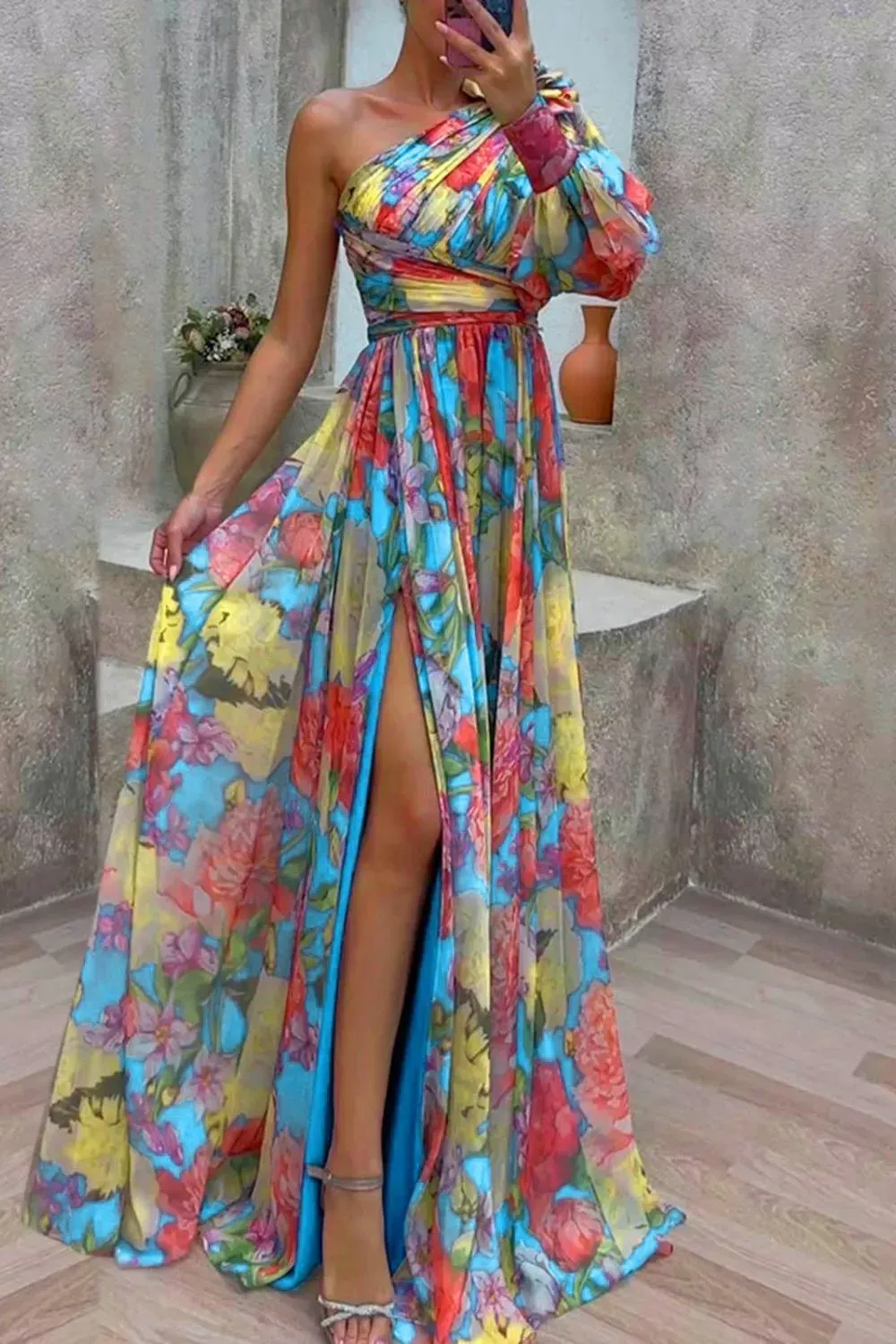 Colorful One-Shoulder Maxi Dress - Woman in a bright floral one-shoulder maxi dress with slit