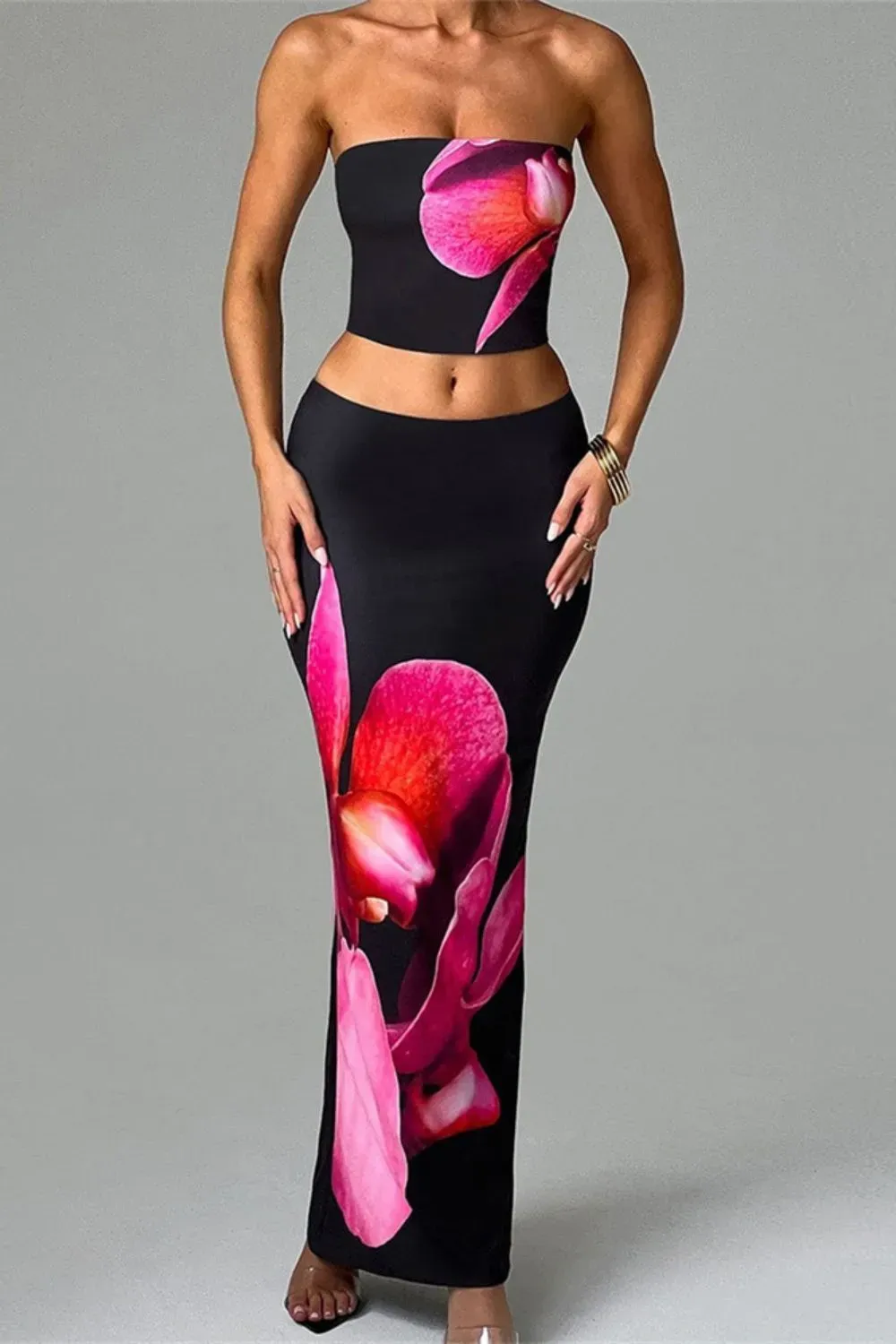 Woman in matching floral bandeau top and skirt set with vibrant orchid prints.