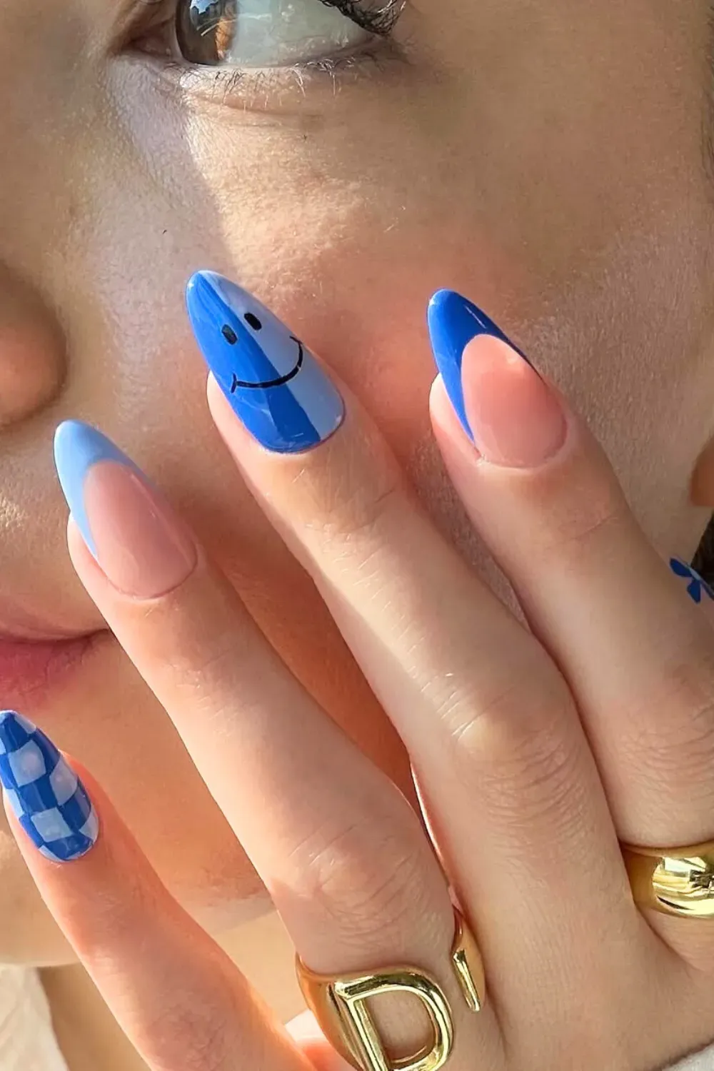 Pastel blue mix-and-match nails with checkerboard and striped patterns.