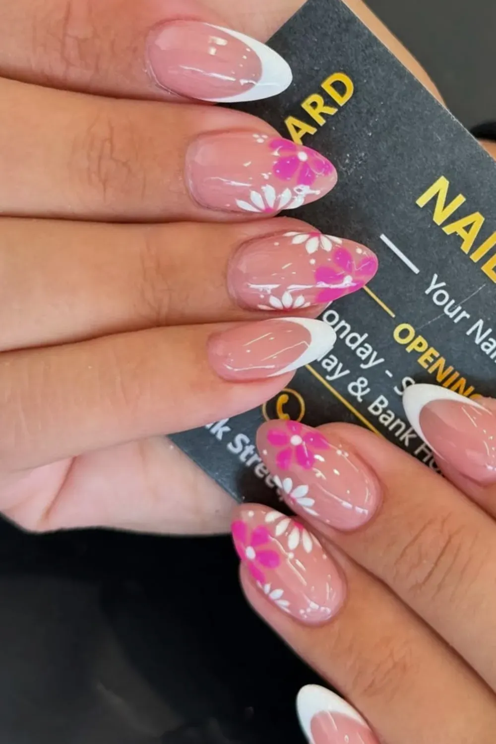 Pink Floral French Tips with White Accents - Soft pink French tip nails with a cute white flower design, perfect for a feminine and romantic look.